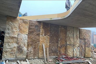 Instalace megalitických obkladů z pískovce na stěnách moderní budovy v lokalitě Praha – Zdiby