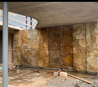 Instalace megalitických obkladů z pískovce na stěnách moderní budovy v lokalitě Praha – Zdiby