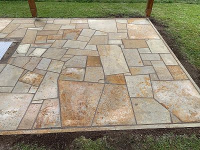 Realizace anglické pískovcové dlažby kolem domu, bazénu a pod dřevěnou pergolou v Lanžově