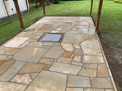 Realizace anglické pískovcové dlažby kolem domu, bazénu a pod dřevěnou pergolou v Lanžově