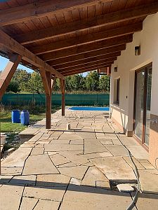 Realizace anglické pískovcové dlažby kolem domu, bazénu a pod dřevěnou pergolou v Lanžově