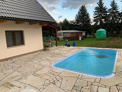 Realizace anglické pískovcové dlažby kolem domu, bazénu a pod dřevěnou pergolou v Lanžově