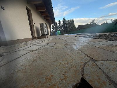 Realizace anglické pískovcové dlažby kolem domu, bazénu a pod dřevěnou pergolou v Lanžově