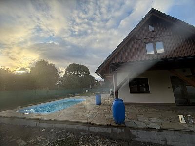 Realizace anglické pískovcové dlažby kolem domu, bazénu a pod dřevěnou pergolou v Lanžově