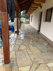 Realizace anglické pískovcové dlažby kolem domu, bazénu a pod dřevěnou pergolou v Lanžově