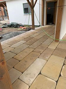 Realizace pásové pískovcové dlažby v rustikálním stylu pod dřevěnou zahradní pergolou v Kuněticích u Pardubic