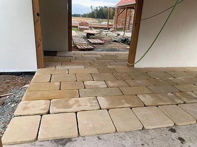 Realizace pásové pískovcové dlažby v rustikálním stylu pod dřevěnou zahradní pergolou v Kuněticích u Pardubic