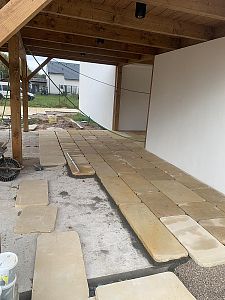 Realizace pásové pískovcové dlažby v rustikálním stylu pod dřevěnou zahradní pergolou v Kuněticích u Pardubic